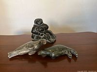 Group view of seated figure and two seals