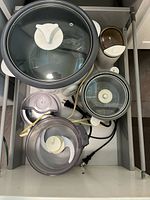 All four appliances stored in drawer showing shapes and lids