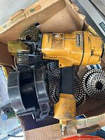 Boxed Stanley Bostitch yellow pneumatic coil nailer with black magazine and coils of nails