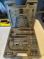 open grey tool case showing sockets, ratchets, wrenches