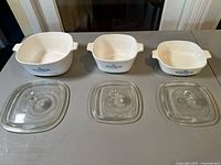 Top view of three CorningWare Blue Cornflower casseroles with lids lined up on table