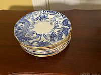 Stack of eight Blue Mikado dessert plates showing gold rims