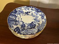 Stack of six blue and white plates showing top design