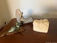 All three stone carvings displayed together on tabletop