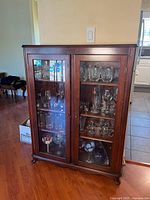 Full front view showing two glass doors, shelves and overall finish