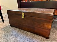 Front angled view of wooden chest showing latch and size