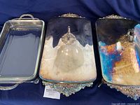Three silver-plate casserole dishes with glass inserts and lids displayed side-by-side