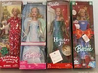 Group shot of four boxed Holiday Barbie dolls