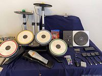 Full lot showing drum kit, game, DJ Hero turntable, dongles