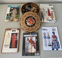 Group shot of tin, tray with thread, four patterns and cross-stitch kit