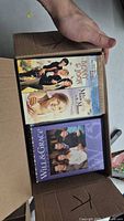 Open box showing Benny & Joon DVD, unidentified DVD, and Will & Grace set
