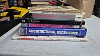 Stack of seven architecture books showing spines for title verification