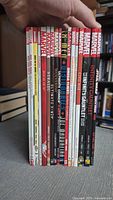 16 Marvel trade paperbacks standing upright, spines visible