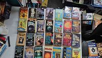 Tabletop layout of approximately 27 mass-market science-fiction paperbacks in six rows