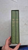 Spine view of two hardcover volumes in slipcase showing titles and condition