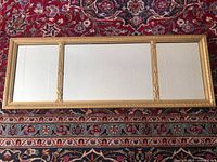 Full view of the three-section rectangular gilt mirror