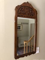 Full view of wall-mounted carved wood mirror