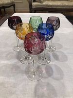 Six multicolour crystal hock glasses arranged in two rows on white cloth