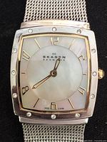 Front view showing dial, bezel crystals, brand logo