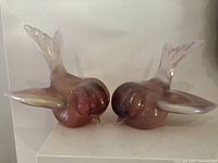 Front view of both glass bird sculptures showing size, color, and shape