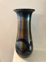 Full view of iridescent glass vase front, flared rim, applied motifs
