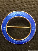 Front view showing blue enamel circular brooch