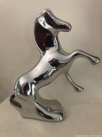 Left side view of polished aluminum rearing horse sculpture