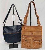 Front view of both Roots crossbody bags side by side showing overall design and size