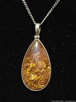 Close-up of teardrop quartz pendant showing inclusions and silver bezel