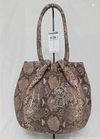 Front view of snake-print leather hobo handbag with MK charm visible