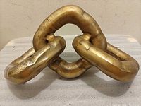 Front view of brass chain-link sculpture