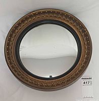 Front view showing full round convex mirror and decorative frame