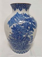 Front view of blue and white Japanese pottery vase showing landscape decoration
