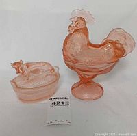 Rooster and cow covered candy dishes side by side