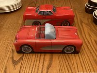 Top view of two red vintage car tins on wood table