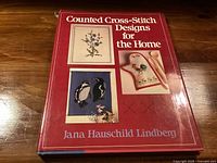 Front cover showing title, author and sample cross-stitch designs