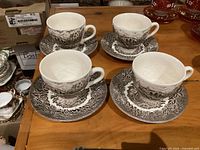 Set of four cups on four saucers displayed