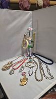 Entire lot with jewelry holder and assorted necklaces, bracelets, earrings, brooches and ring laid out