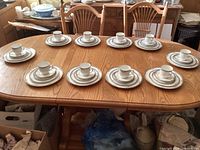 Entire 50-piece set laid out in ten stacked place settings on table