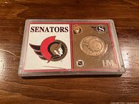 Front of display case showing Senators logo, bronze medal, HM mark
