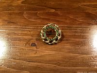 Front view showing wreath design and green stones