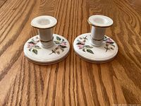 Pair of Wedgwood Hathaway Rose candlesticks on wood surface
