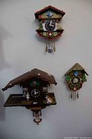 All three small cuckoo clocks mounted on wall