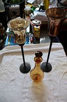 Decanter with stopper and two candle holders standing on towel