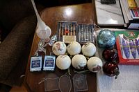 Overview of all ornaments on table including boxed sets, ball ornaments, finial topper and novelty pieces