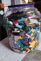 Jar front view showing mixed LEGO pieces and purple lid