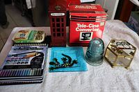 Group shot showing all items: pencil tins, insulator, salamander tray, jewellery box, telephone booth box, Tele-Cine converter