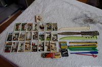 All items laid out: cards, letter openers, swizzle sticks, tins