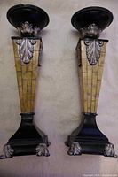Front view of both candlesticks showing tapered columns with faux-ivory panels and acanthus leaf mounts