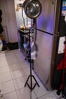 Full view of adjustable spotlight floor lamp on tripod base